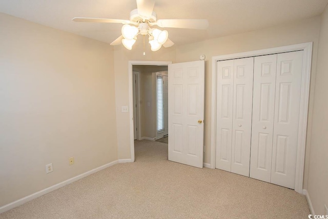 unfurnished bedroom featuring a closet, light colored carpet, and ceiling fan