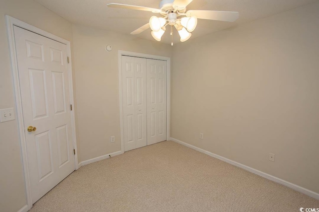 unfurnished bedroom with ceiling fan, a closet, and light colored carpet