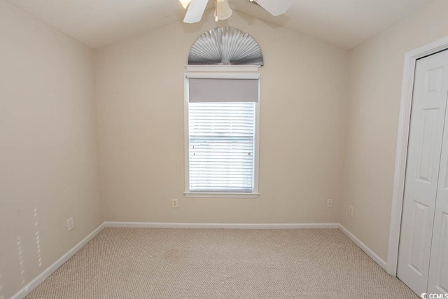 spare room featuring light carpet, ceiling fan, and lofted ceiling