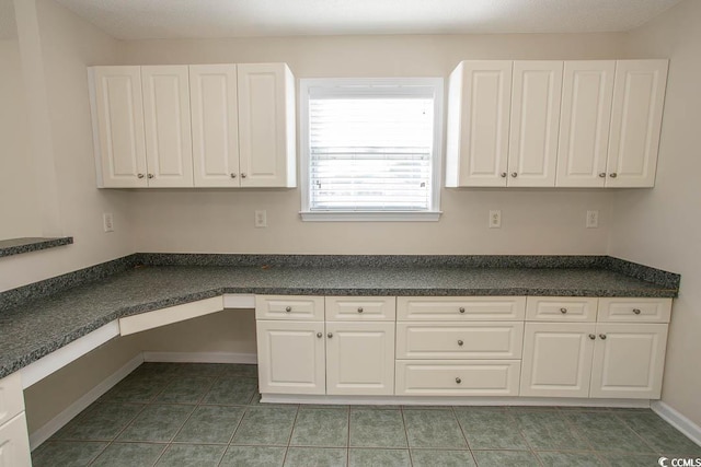 kitchen featuring white cabinetry and dark tile patterned floors