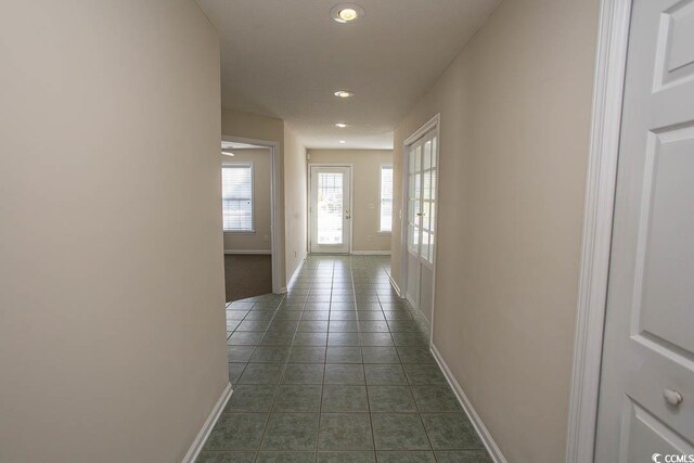 hallway featuring dark tile patterned flooring