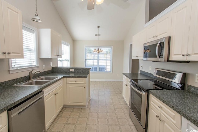 kitchen with decorative light fixtures, stainless steel appliances, vaulted ceiling, and sink