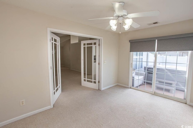 carpeted empty room with french doors and ceiling fan