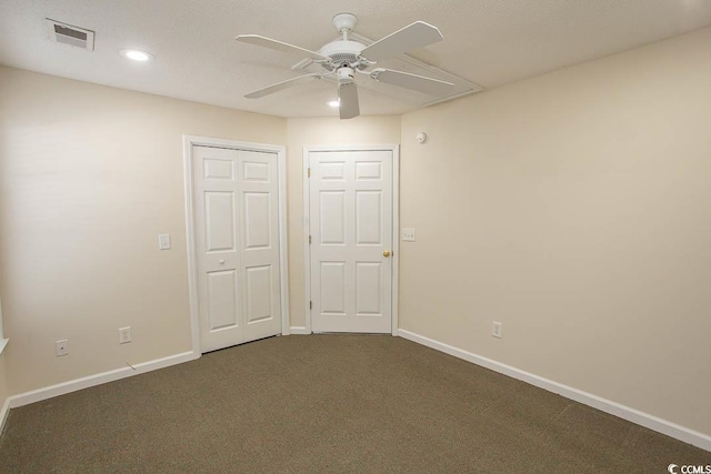 unfurnished bedroom with ceiling fan and dark carpet