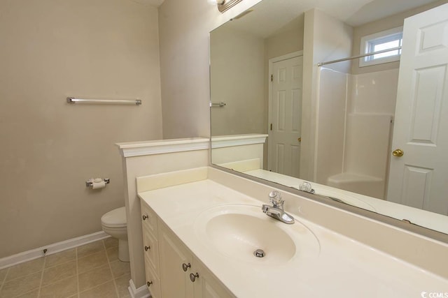 bathroom with a shower, vanity, tile patterned flooring, and toilet