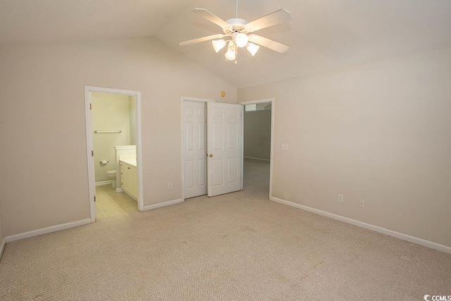 unfurnished bedroom featuring ceiling fan, light carpet, connected bathroom, and vaulted ceiling