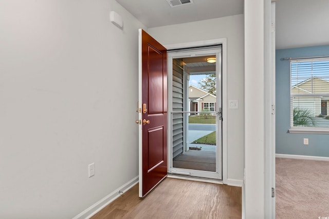 doorway featuring plenty of natural light and light hardwood / wood-style flooring