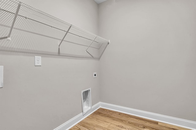 clothes washing area featuring electric dryer hookup and hardwood / wood-style floors