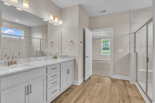 bathroom with a shower with door, vanity, and hardwood / wood-style flooring