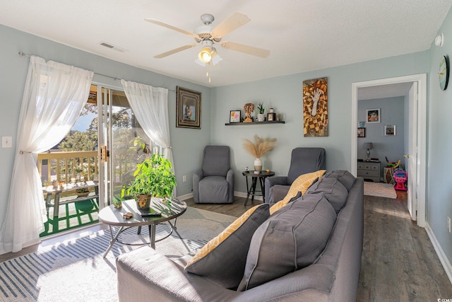 living room with ceiling fan and dark hardwood / wood-style flooring