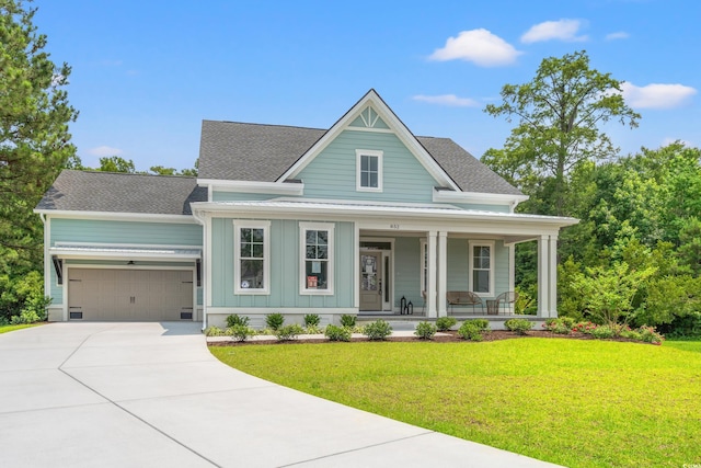 852 Comanders Island Rd, Georgetown, SC 29440 - view of front of house with covered porch, board and batten siding, an attached garage, and a front lawn
