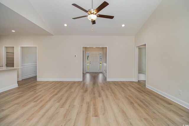 spare room with ceiling fan, lofted ceiling, and light wood-type flooring