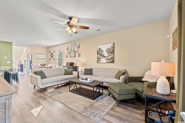 living room with light hardwood / wood-style flooring and ceiling fan