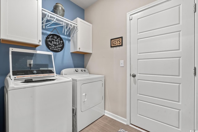 laundry room with washing machine and dryer and cabinets