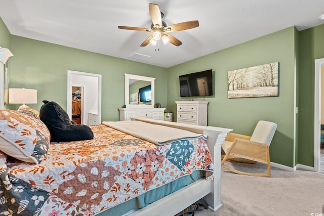 bedroom with a walk in closet, ceiling fan, and carpet