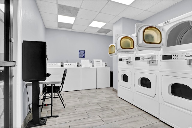 clothes washing area featuring washer and dryer, light wood-type flooring, and stacked washer / drying machine