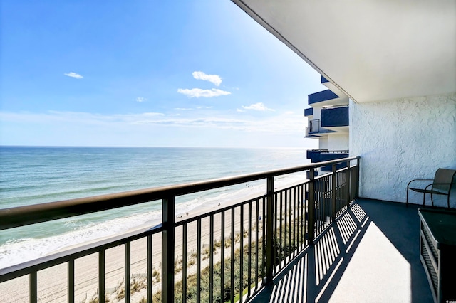 balcony featuring a view of the beach and a water view