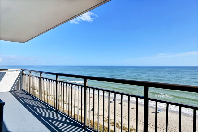 balcony featuring a water view and a view of the beach