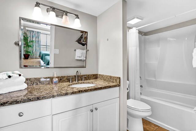 full bathroom featuring tile patterned flooring, shower / bath combination with curtain, vanity, and toilet