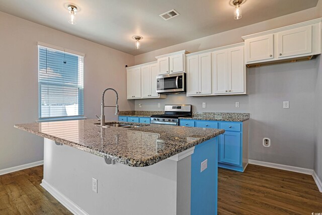 kitchen featuring a center island with sink, white cabinets, appliances with stainless steel finishes, and dark hardwood / wood-style floors