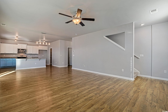 unfurnished living room with ceiling fan and dark hardwood / wood-style floors