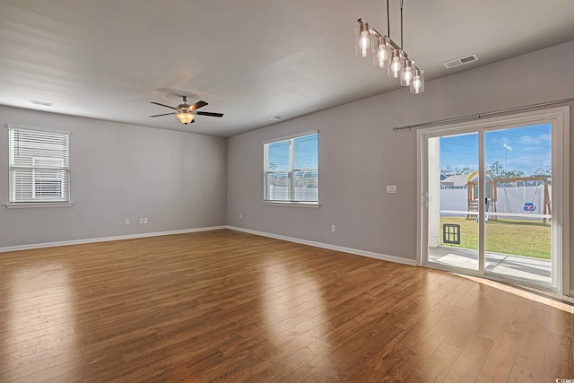 unfurnished room with ceiling fan, hardwood / wood-style flooring, and a healthy amount of sunlight