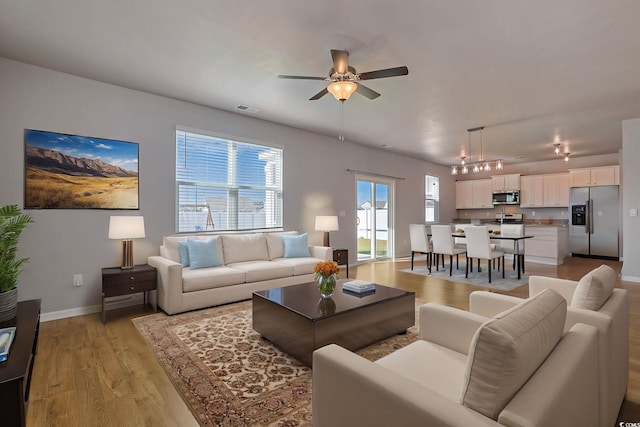 living room featuring ceiling fan and light hardwood / wood-style floors