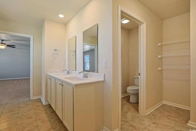 bathroom with tile patterned floors, vanity, toilet, and ceiling fan