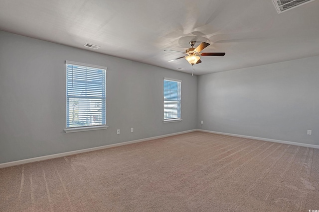 carpeted empty room featuring plenty of natural light and ceiling fan