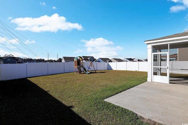 view of yard with a playground, a sunroom, and a patio