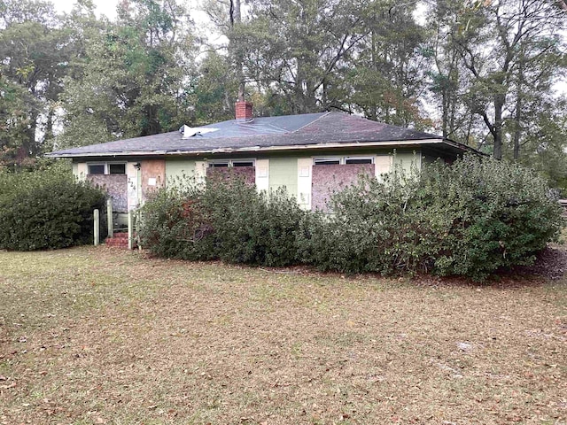 rear view of property featuring a lawn