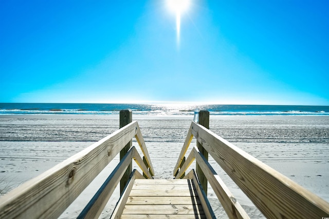 view of property's community with a water view and a view of the beach