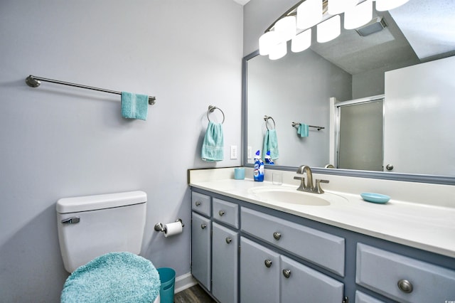 bathroom featuring vanity, hardwood / wood-style flooring, toilet, and walk in shower