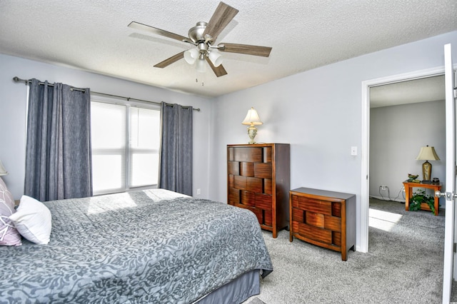 bedroom with a textured ceiling, ceiling fan, and light carpet