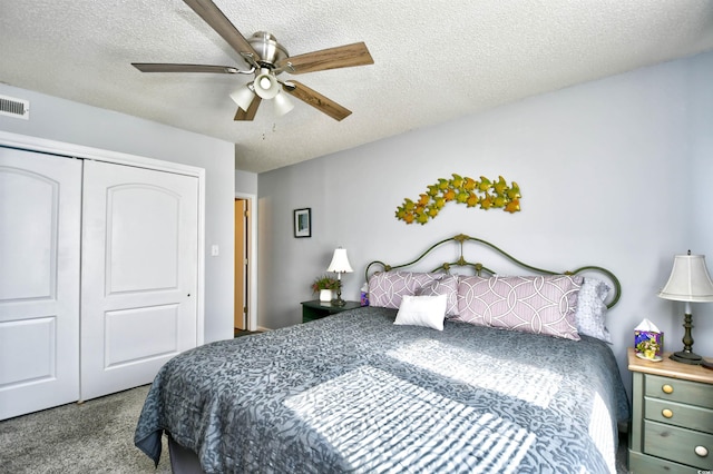 carpeted bedroom with ceiling fan, a closet, and a textured ceiling