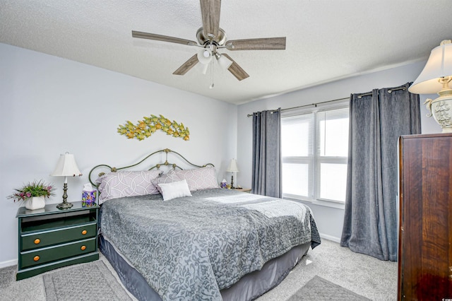 carpeted bedroom with ceiling fan and a textured ceiling