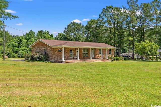 ranch-style house featuring covered porch and a front lawn