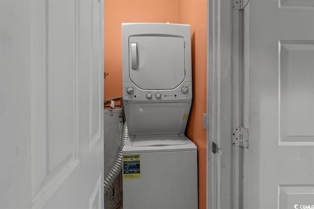 washroom featuring stacked washer / drying machine