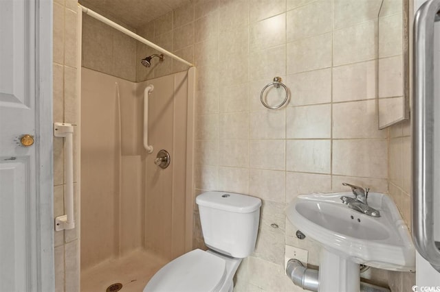 bathroom featuring tiled shower, toilet, and tile walls