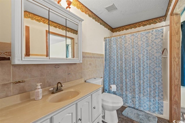 full bathroom featuring shower / tub combo, vanity, a textured ceiling, tile walls, and toilet