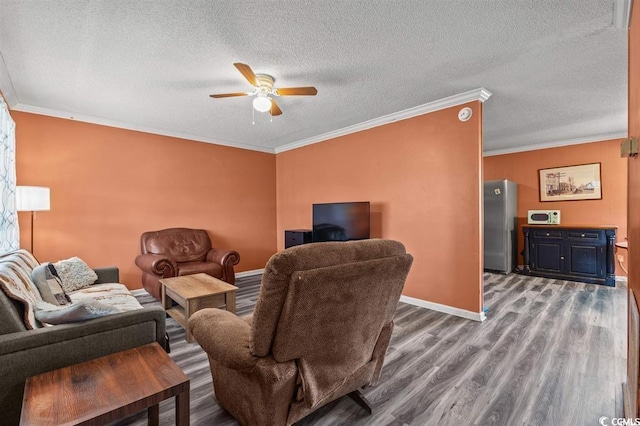 living room with hardwood / wood-style floors, a textured ceiling, ceiling fan, and crown molding