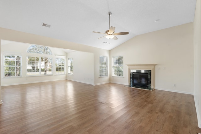 unfurnished living room featuring ceiling fan, a high end fireplace, vaulted ceiling, and hardwood / wood-style flooring