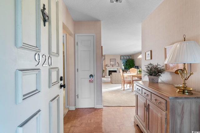 foyer entrance featuring a textured ceiling and light parquet floors