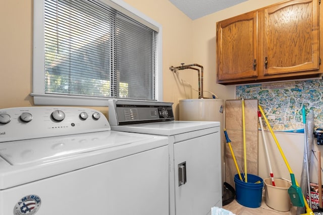 clothes washing area with cabinets, separate washer and dryer, and a textured ceiling