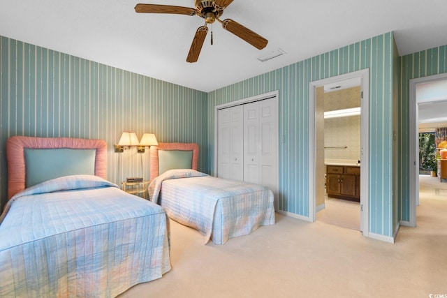 carpeted bedroom featuring connected bathroom, a closet, and ceiling fan