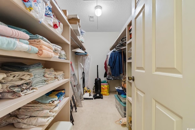 walk in closet featuring light carpet