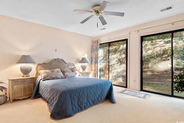 bedroom featuring access to outside, multiple windows, ceiling fan, and carpet flooring