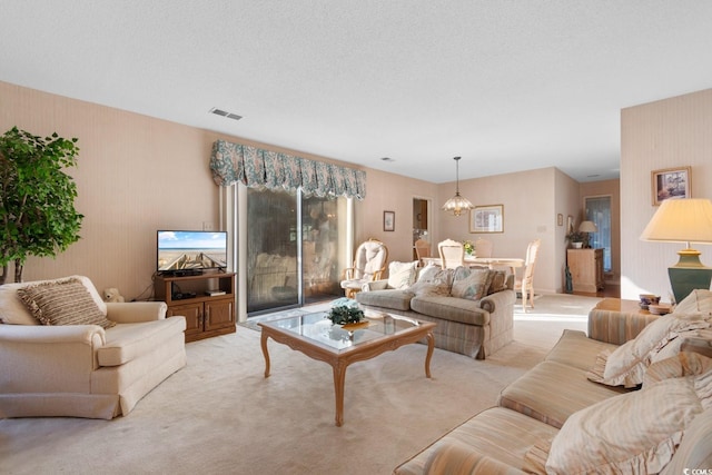 carpeted living room featuring a textured ceiling and an inviting chandelier