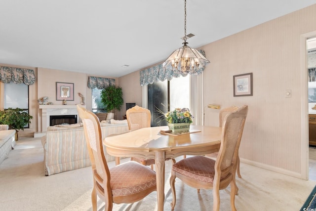 carpeted dining space featuring an inviting chandelier