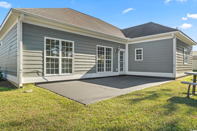 rear view of house featuring a lawn and a patio